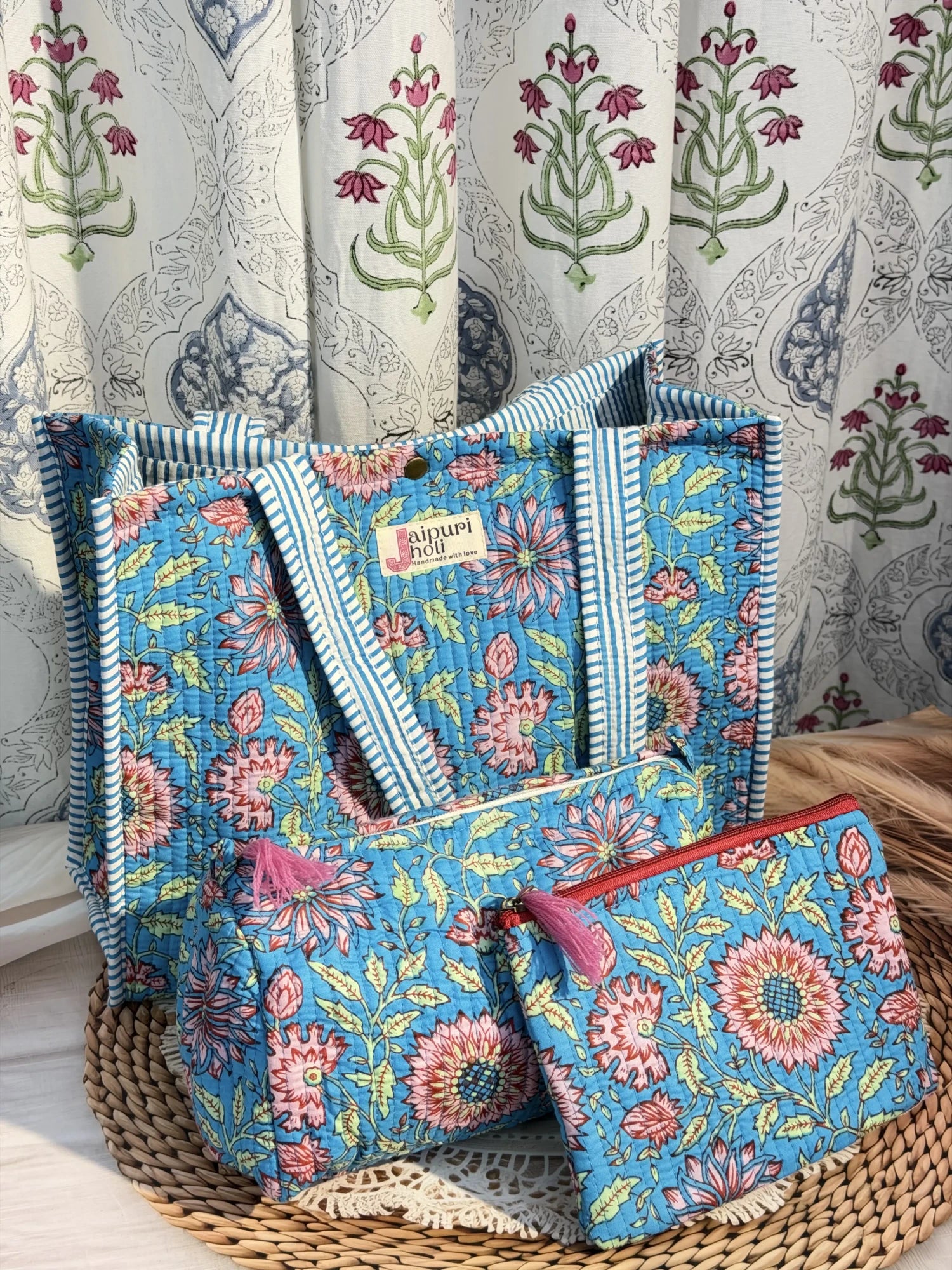 Jaipur block print medium cotton quilted reversible tote bag with matching toiletry pouch and flat pouch, blue floral print, 15 × 12 × 6 inch tote with button closure, 10 × 6 inch toiletry pouch and 9 × 7 inch flat pouch side view