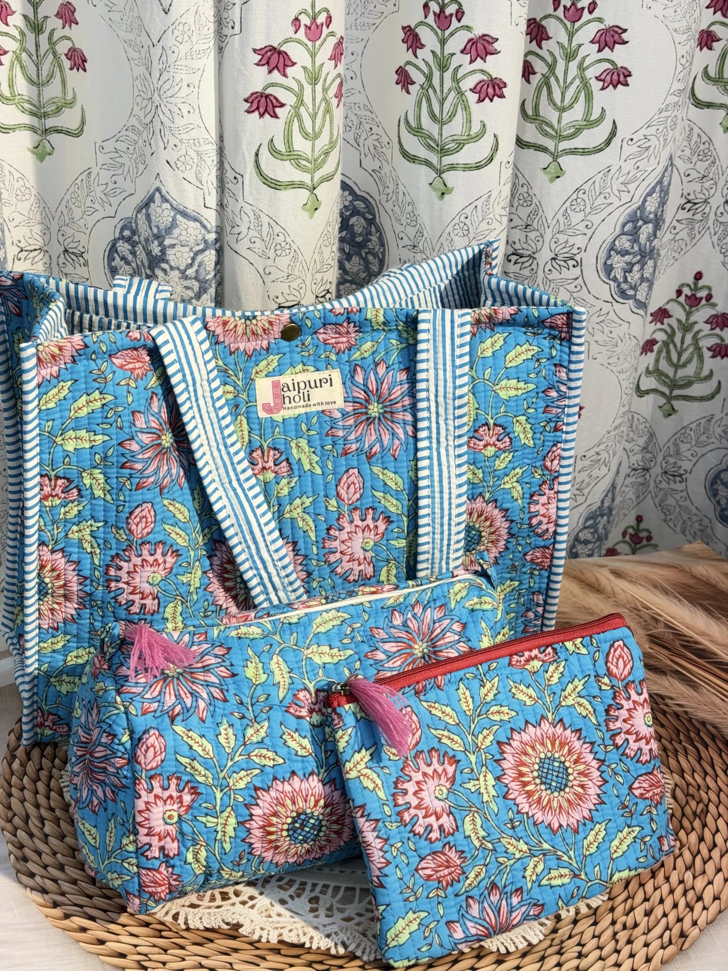 Jaipur block print medium cotton quilted reversible tote bag with matching toiletry pouch and flat pouch, blue floral print, 15 × 12 × 6 inch tote with button closure, 10 × 6 inch toiletry pouch and 9 × 7 inch flat pouch front view