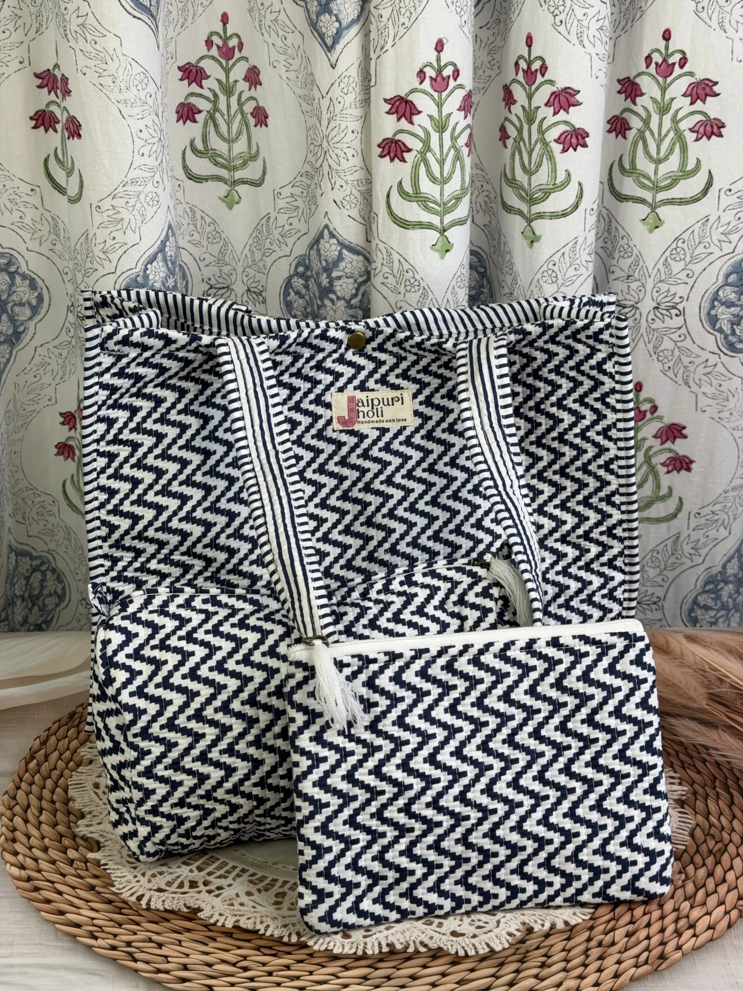 Jaipur block print medium cotton quilted reversible tote bag with matching toiletry pouch and flat pouch, blue and white geometric zigzag print, 15 × 12 × 6 inch tote with button closure, 10 × 6 inch toiletry pouch and 9 × 7 inch flat pouch front view