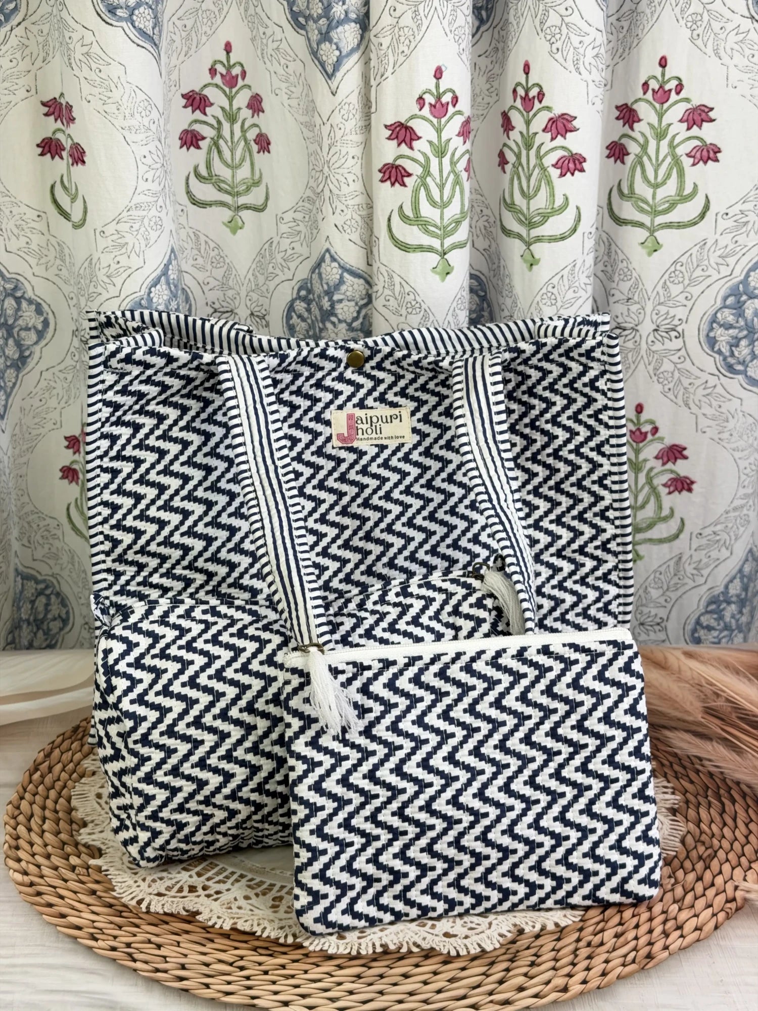 Jaipur block print medium cotton quilted reversible tote bag with matching toiletry pouch and flat pouch, blue and white geometric zigzag print, 15 × 12 × 6 inch tote with button closure, 10 × 6 inch toiletry pouch and 9 × 7 inch flat pouch side view