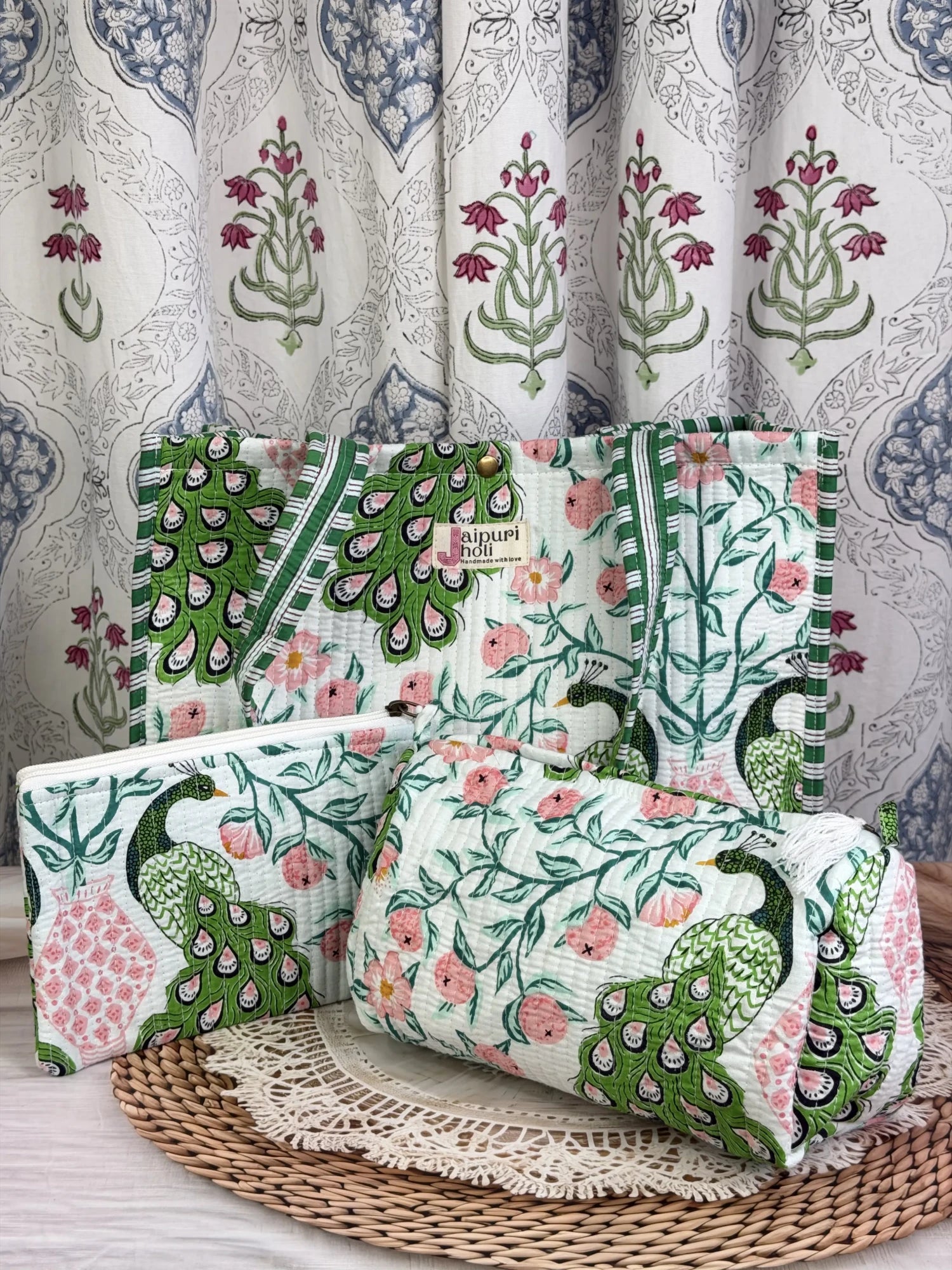 Jaipur block print medium cotton quilted reversible tote bag with matching toiletry pouch and flat pouch, green and pink peacock print, 15 × 12 × 6 inch tote with button closure, 10 × 6 inch toiletry pouch and 9 × 7 inch flat pouch front view
