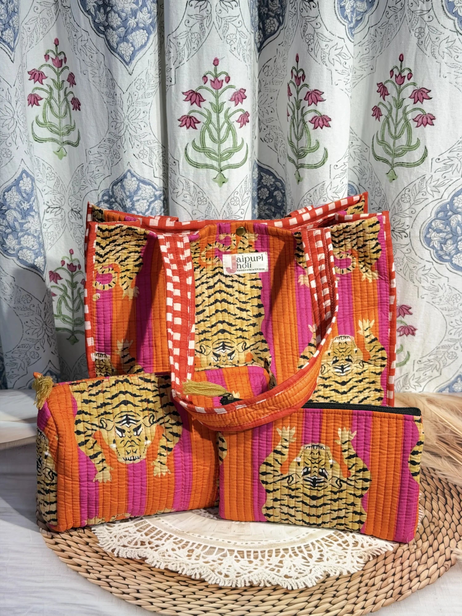 Jaipur block print medium cotton quilted reversible tote bag with matching toiletry pouch and flat pouch, orange and pink tiger print, 15 × 12 × 6 inch tote with button closure, 10 × 6 inch toiletry pouch and 9 × 7 inch flat pouch side view