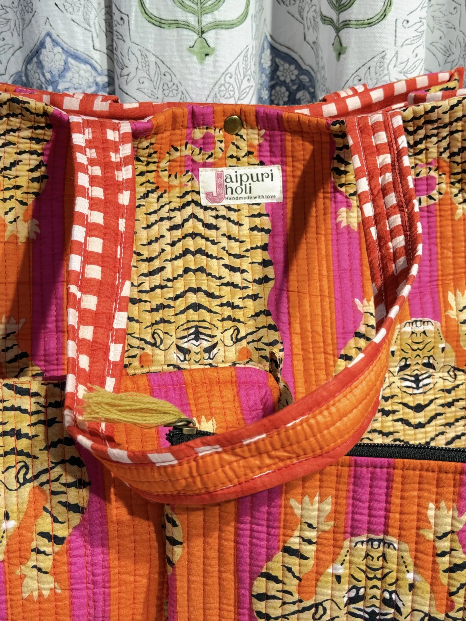 Jaipur block print medium cotton quilted reversible tote bag with matching toiletry pouch and flat pouch, orange and pink tiger print, 15 × 12 × 6 inch tote with button closure, 10 × 6 inch toiletry pouch and 9 × 7 inch flat pouch back view