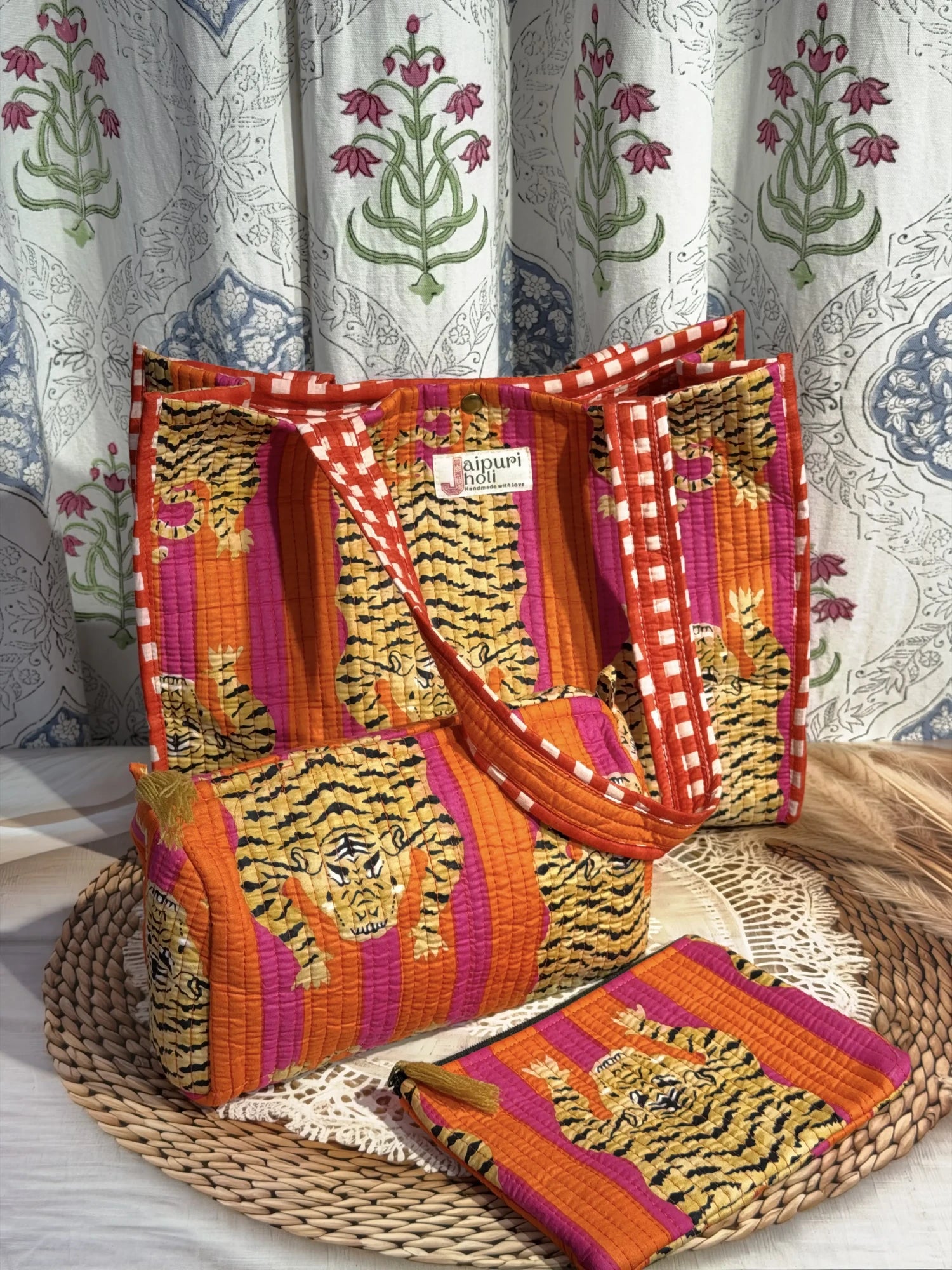 Jaipur block print medium cotton quilted reversible tote bag with matching toiletry pouch and flat pouch, orange and pink tiger print, 15 × 12 × 6 inch tote with button closure, 10 × 6 inch toiletry pouch and 9 × 7 inch flat pouch close-up view