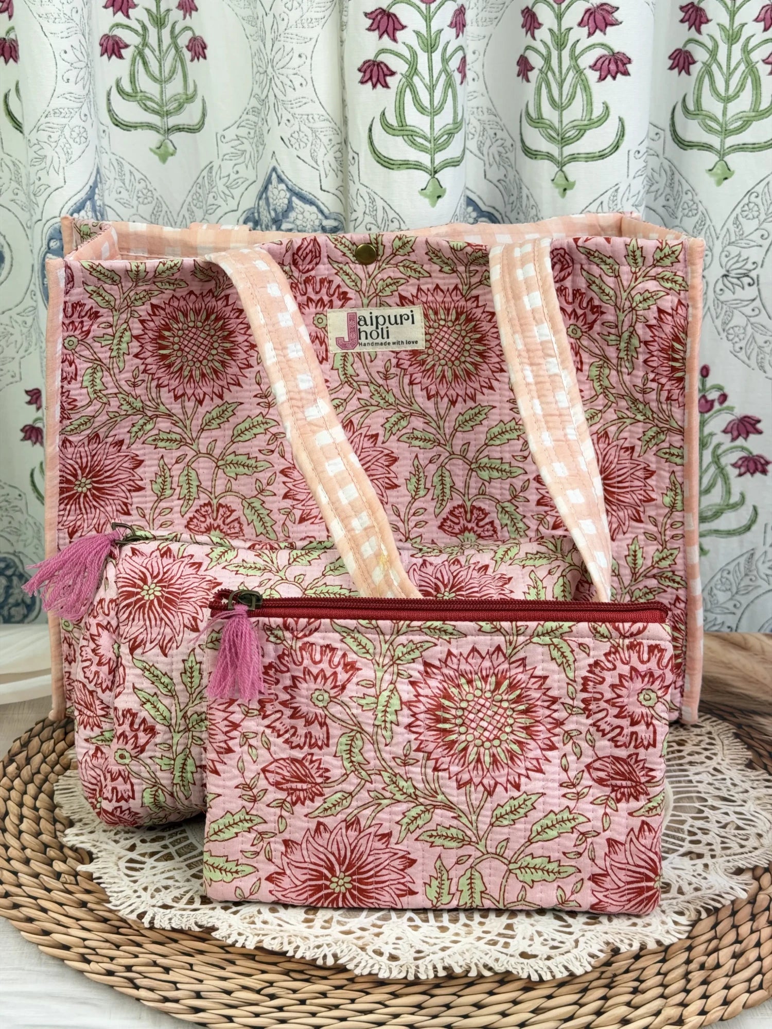 Jaipur block print medium cotton quilted reversible tote bag with matching toiletry pouch and flat pouch, peach and pink floral print, 15 × 12 × 6 inch tote with button closure, 10 × 6 inch toiletry pouch and 9 × 7 inch flat pouch front view