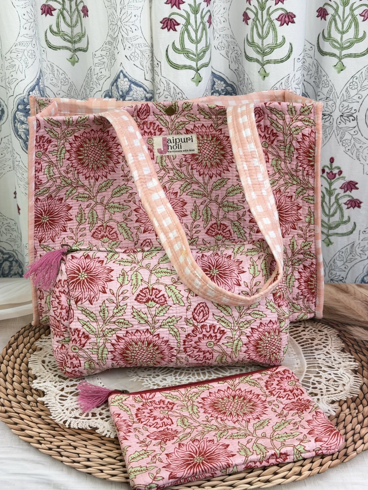 Jaipur block print medium cotton quilted reversible tote bag with matching toiletry pouch and flat pouch, peach and pink floral print, 15 × 12 × 6 inch tote with button closure, 10 × 6 inch toiletry pouch and 9 × 7 inch flat pouch side view
