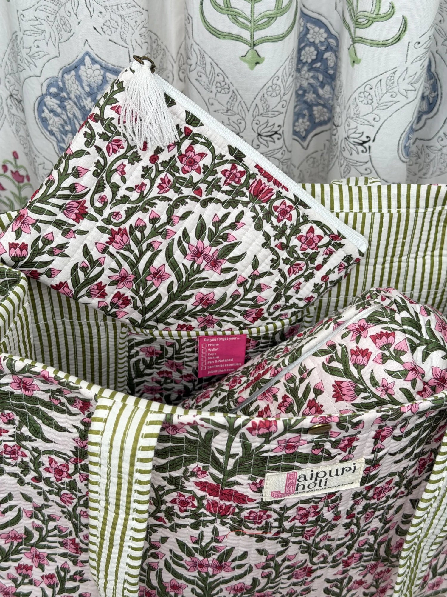 Jaipur block print medium cotton quilted reversible tote bag with matching toiletry pouch and flat pouch, pink floral and green leaf print, 15 × 12 × 6 inch tote with button closure, 10 × 6 inch toiletry pouch and 9 × 7 inch flat pouch close-up view