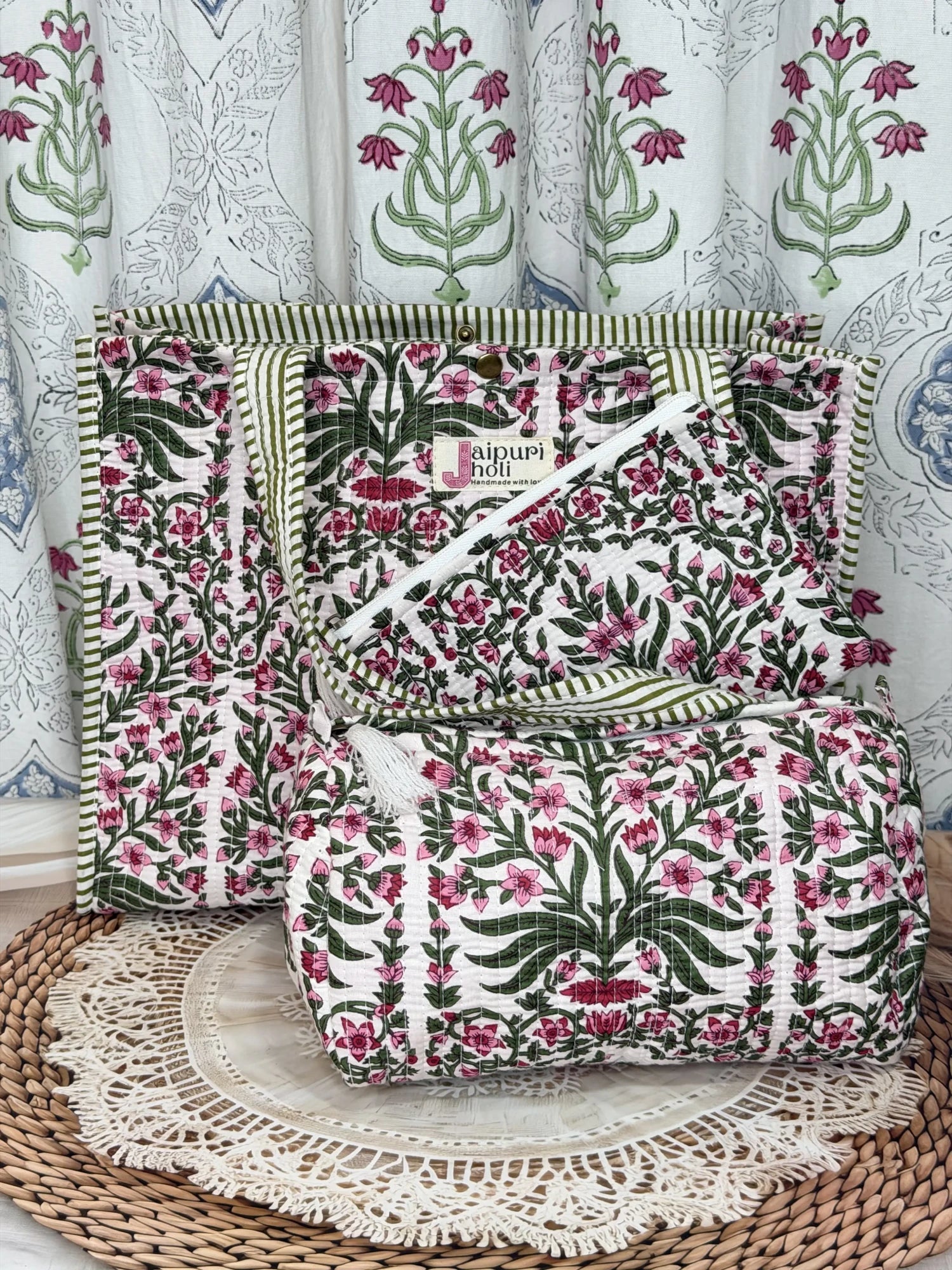 Jaipur block print medium cotton quilted reversible tote bag with matching toiletry pouch and flat pouch, pink floral and green leaf print, 15 × 12 × 6 inch tote with button closure, 10 × 6 inch toiletry pouch and 9 × 7 inch flat pouch side view