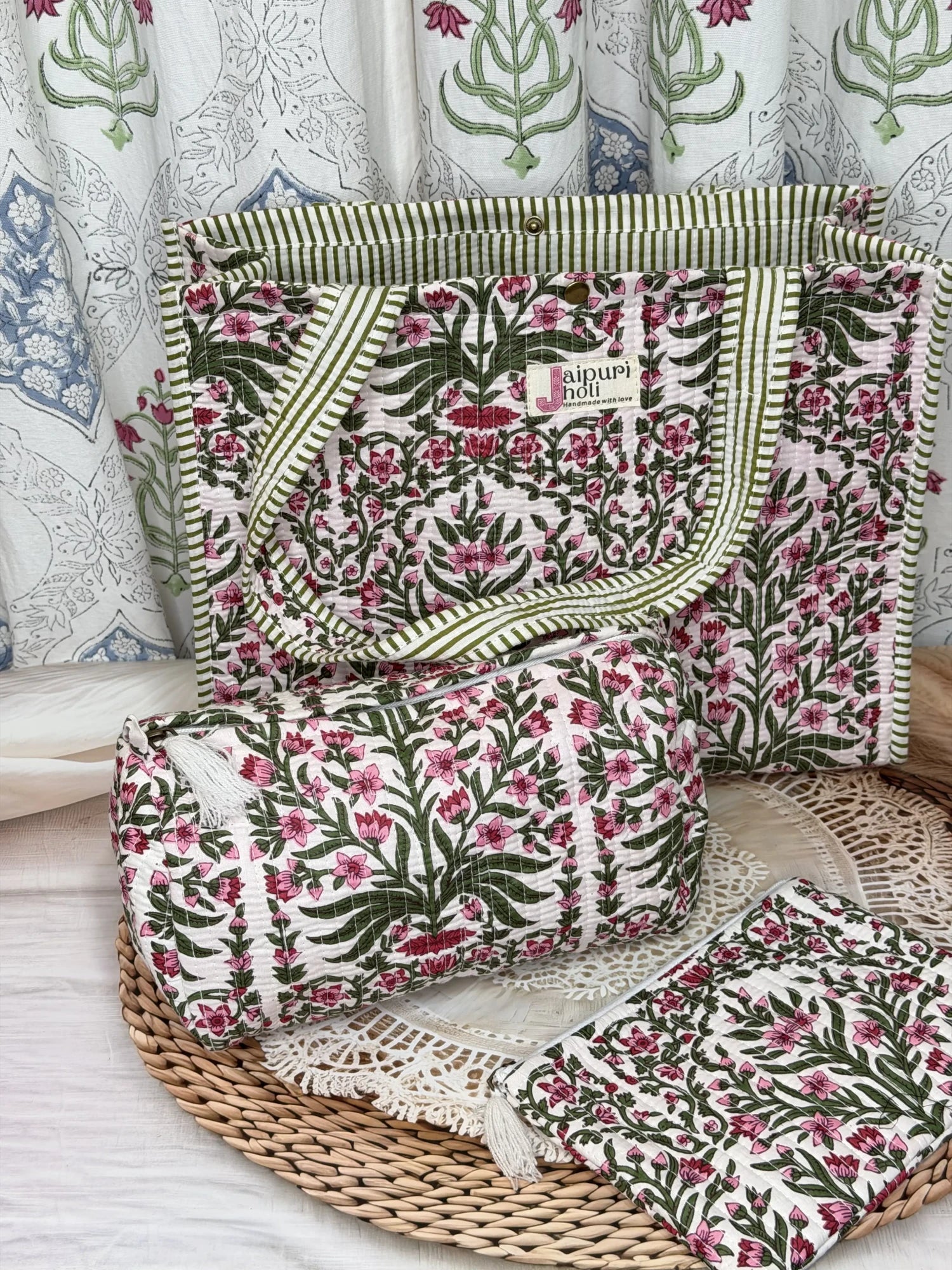 Jaipur block print medium cotton quilted reversible tote bag with matching toiletry pouch and flat pouch, pink floral and green leaf print, 15 × 12 × 6 inch tote with button closure, 10 × 6 inch toiletry pouch and 9 × 7 inch flat pouch front view