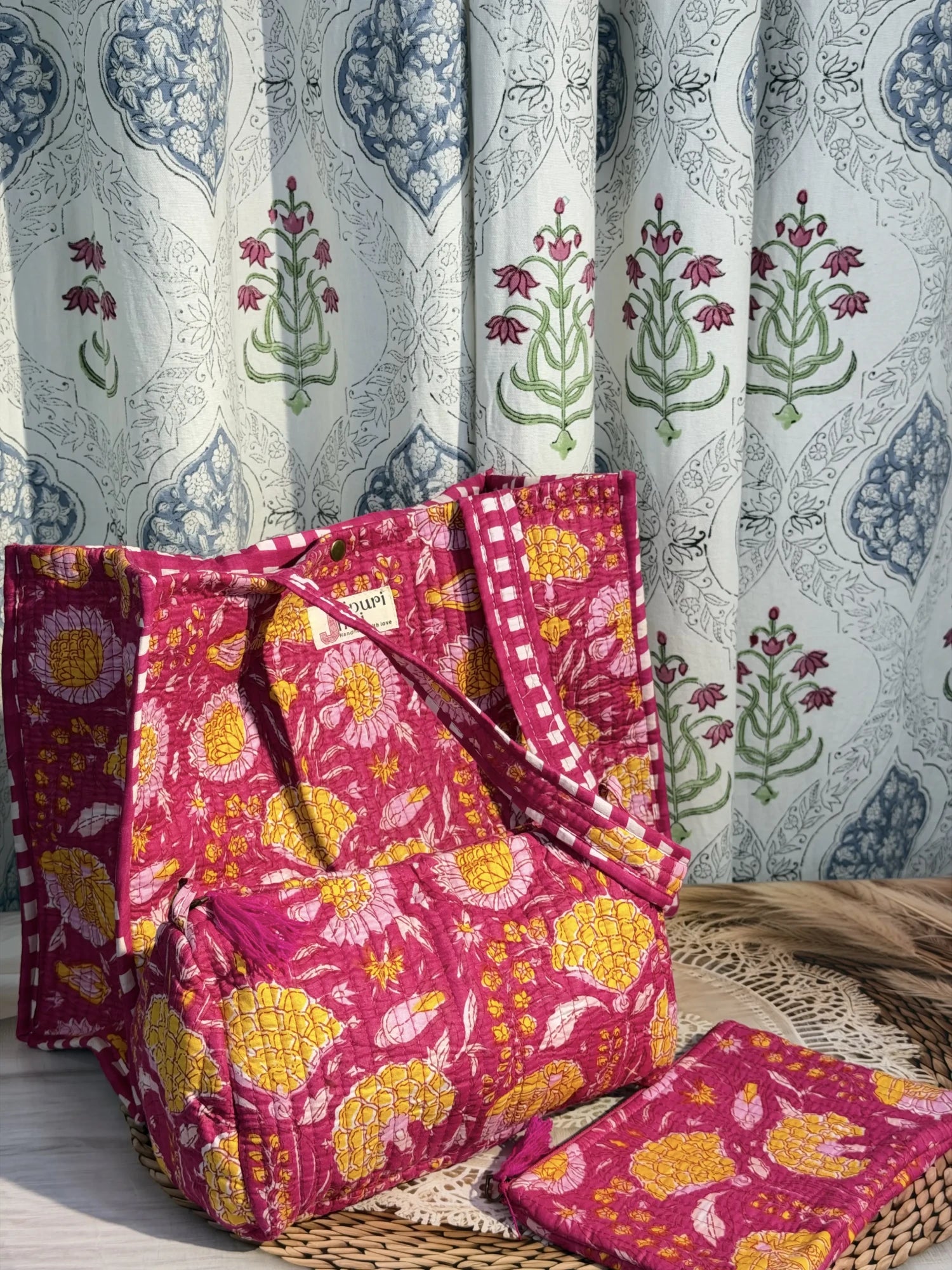 Jaipur block print medium cotton quilted reversible tote bag with matching toiletry pouch and flat pouch, pink floral print, 15 × 12 × 6 inch tote with button closure, 10 × 6 inch toiletry pouch and 9 × 7 inch flat pouch side view