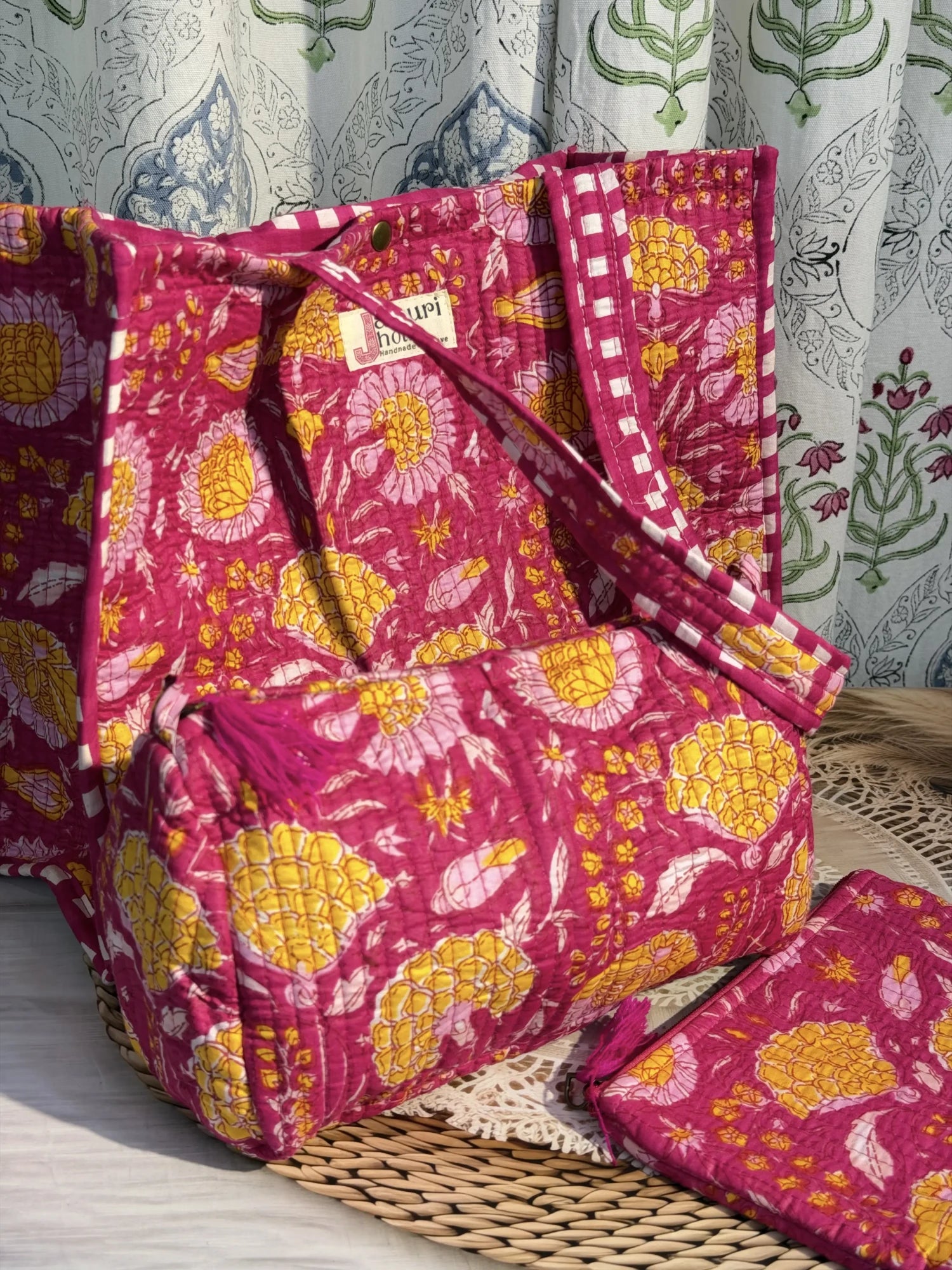 Jaipur block print medium cotton quilted reversible tote bag with matching toiletry pouch and flat pouch, pink floral print, 15 × 12 × 6 inch tote with button closure, 10 × 6 inch toiletry pouch and 9 × 7 inch flat pouch front view
