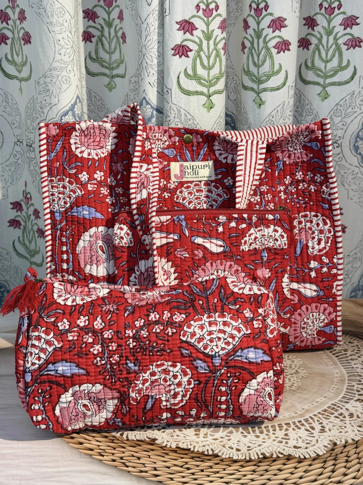 Jaipur block print medium cotton quilted reversible tote bag with matching toiletry pouch and flat pouch, red floral print, 15 × 12 × 6 inch tote with button closure, 10 × 6 inch toiletry pouch and 9 × 7 inch flat pouch side view