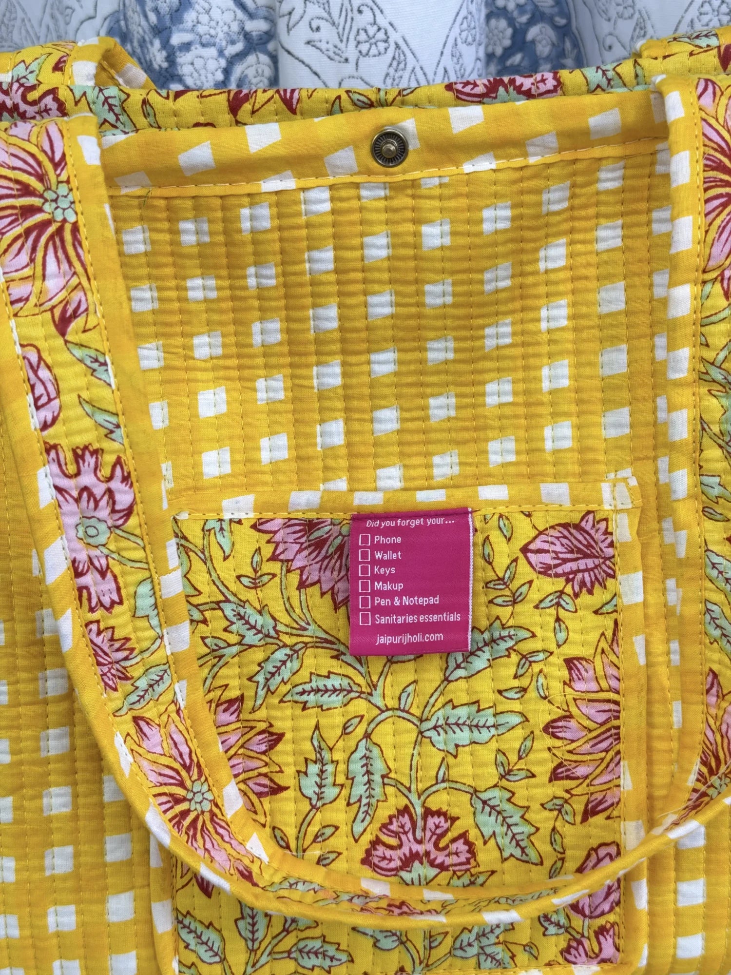 Jaipur block print medium cotton quilted reversible tote bag with matching toiletry pouch and flat pouch, yellow floral print, 15 × 12 × 6 inch tote with button closure, 10 × 6 inch toiletry pouch and 9 × 7 inch flat pouch interior view