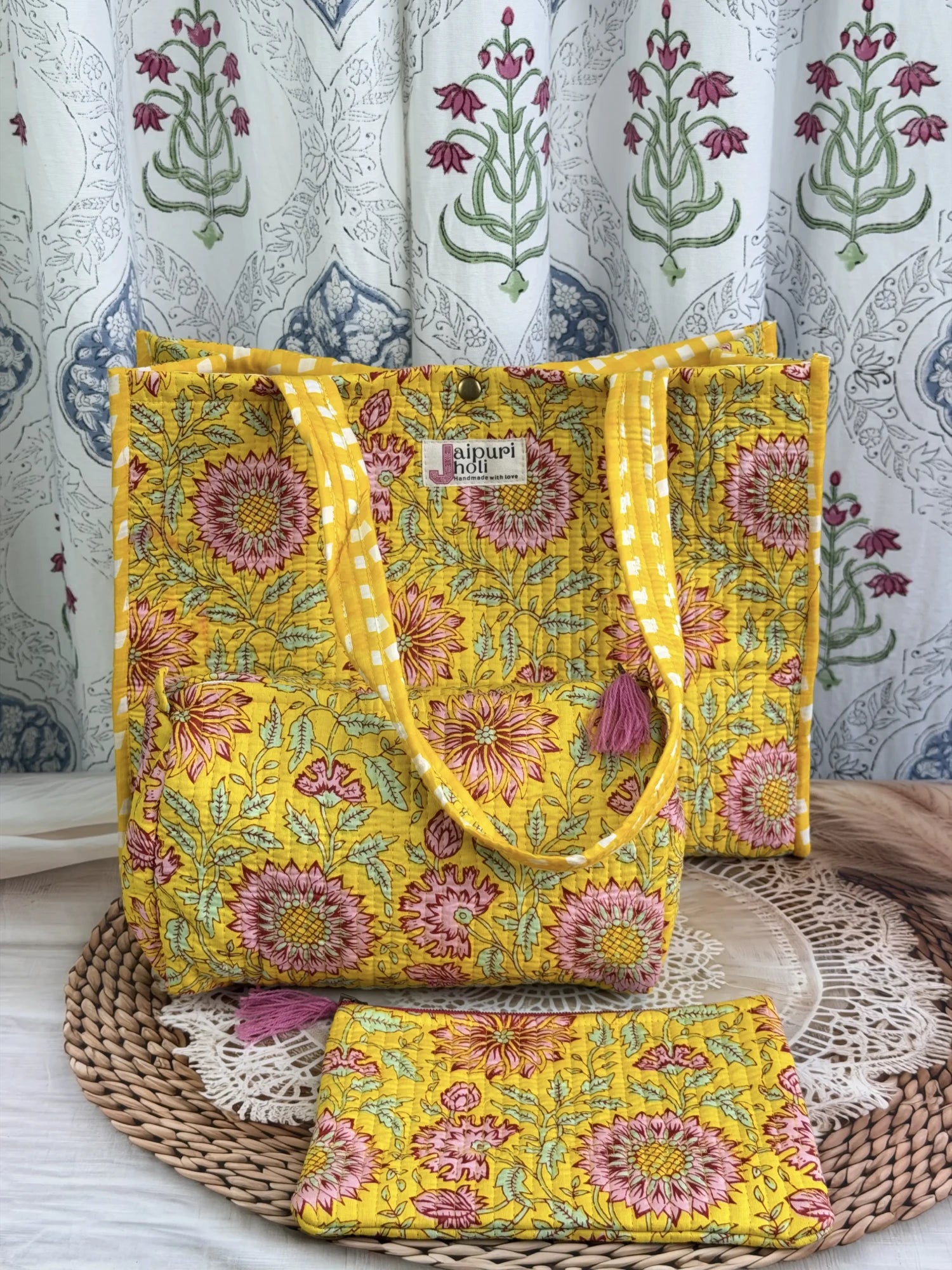 Jaipur block print medium cotton quilted reversible tote bag with matching toiletry pouch and flat pouch, yellow floral print, 15 × 12 × 6 inch tote with button closure, 10 × 6 inch toiletry pouch and 9 × 7 inch flat pouch front view