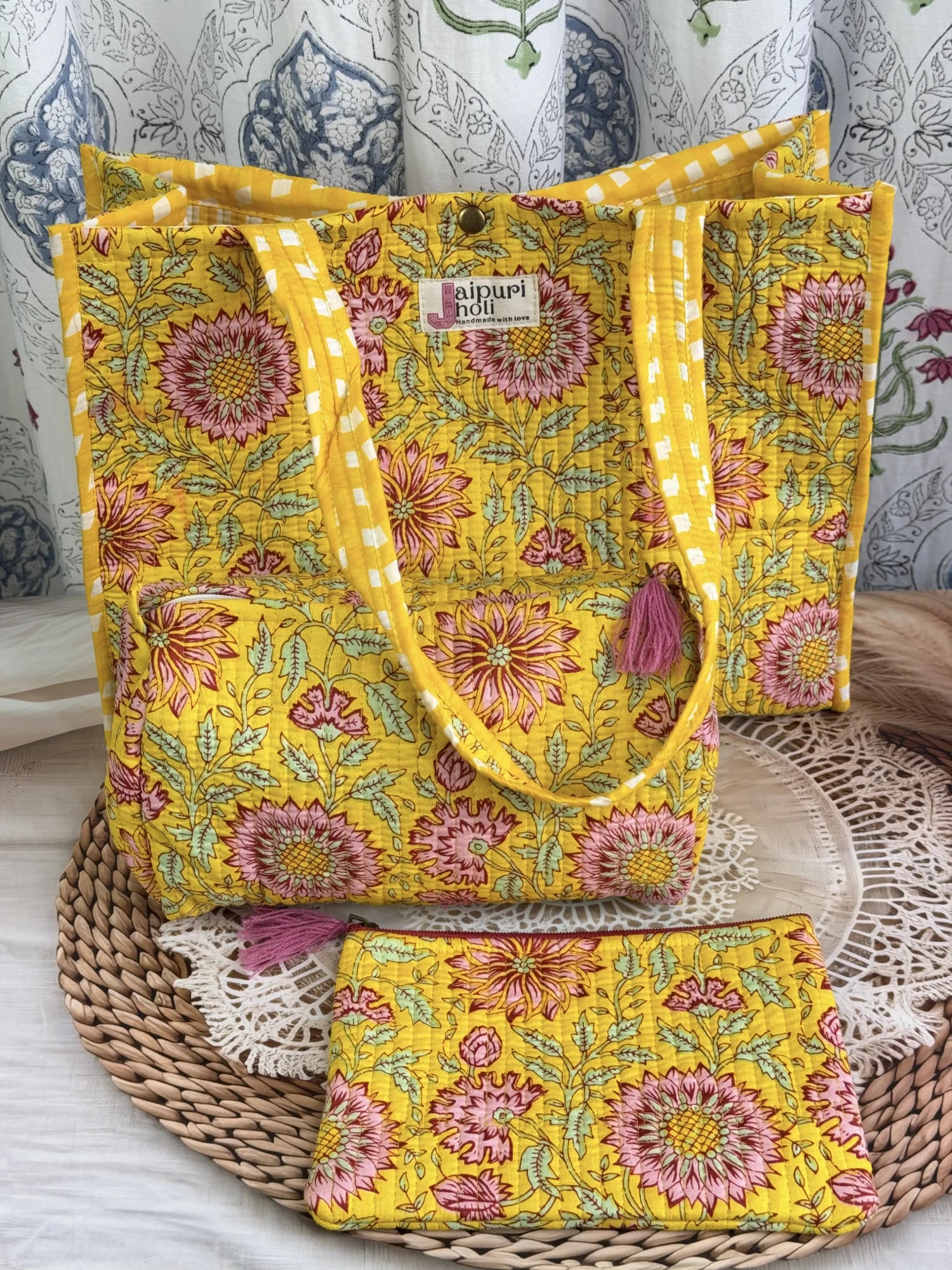 Jaipur block print medium cotton quilted reversible tote bag with matching toiletry pouch and flat pouch, yellow floral print, 15 × 12 × 6 inch tote with button closure, 10 × 6 inch toiletry pouch and 9 × 7 inch flat pouch side view