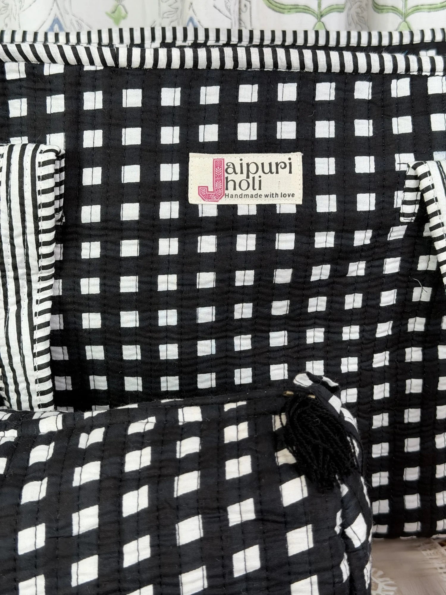 Jaipur block print medium cotton quilted zip tote bag with matching toiletry pouch and flat pouch, black and white geometric check print, 15 × 12 × 6 inch tote, 10 × 6 inch toiletry pouch and 9 × 7 inch flat pouch close-up view