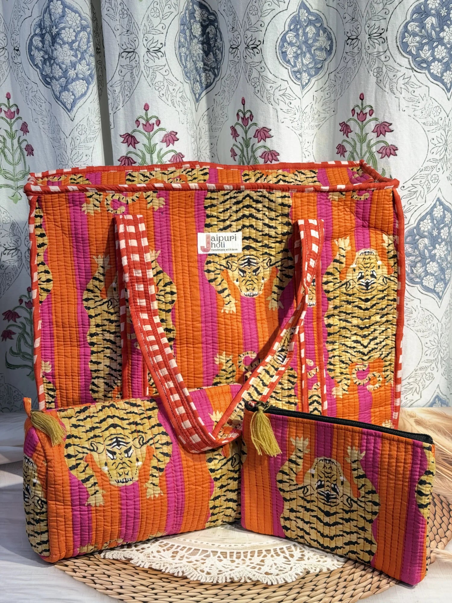 Jaipur block print medium cotton quilted reversible tote bag with matching toiletry pouch and flat pouch, orange and pink tiger print, 15 × 12 × 6 inch tote with button closure, 10 × 6 inch toiletry pouch and 9 × 7 inch flat pouch front view
