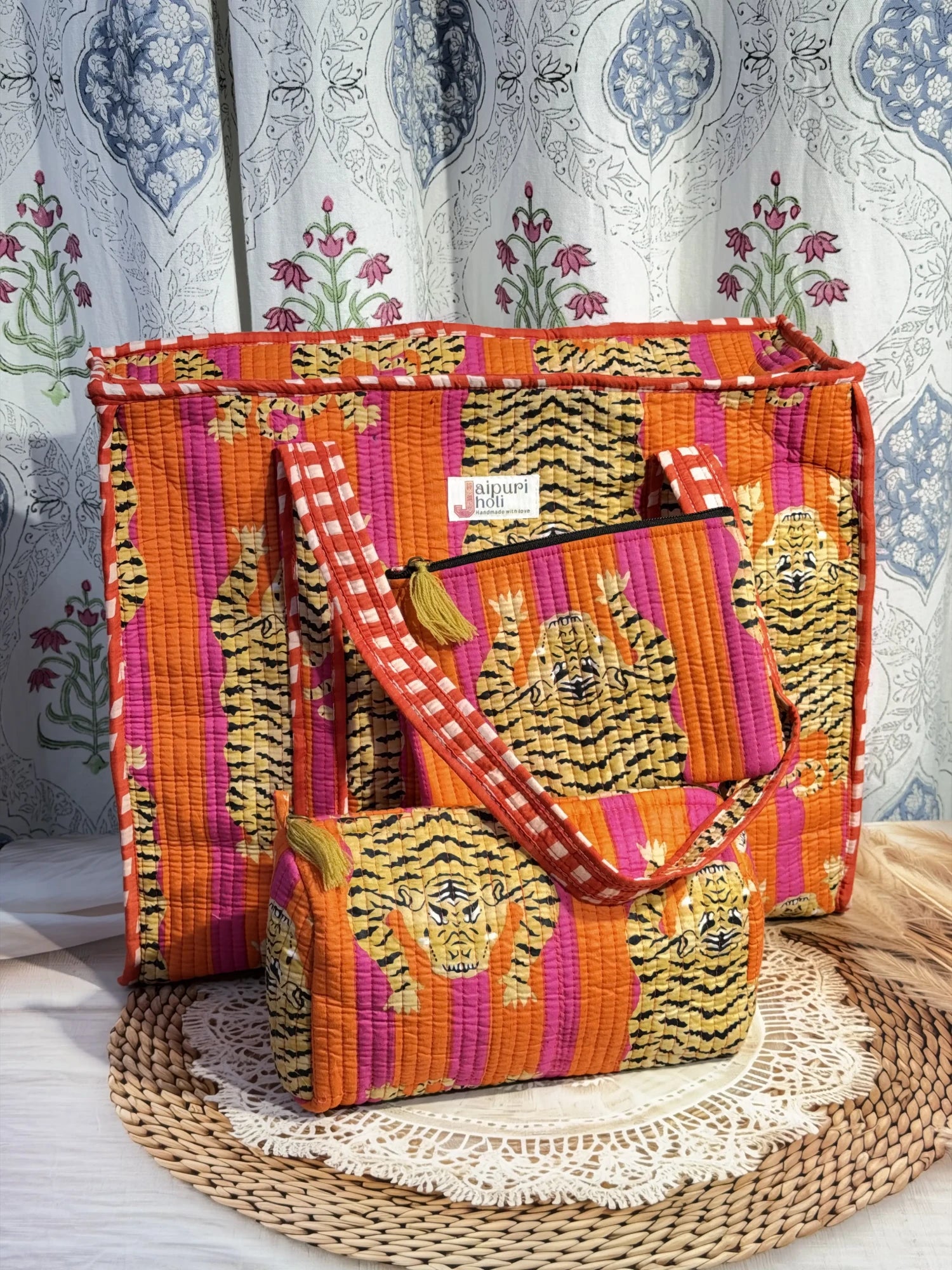 Jaipur block print medium cotton quilted reversible tote bag with matching toiletry pouch and flat pouch, orange and pink tiger print, 15 × 12 × 6 inch tote with button closure, 10 × 6 inch toiletry pouch and 9 × 7 inch flat pouch side view