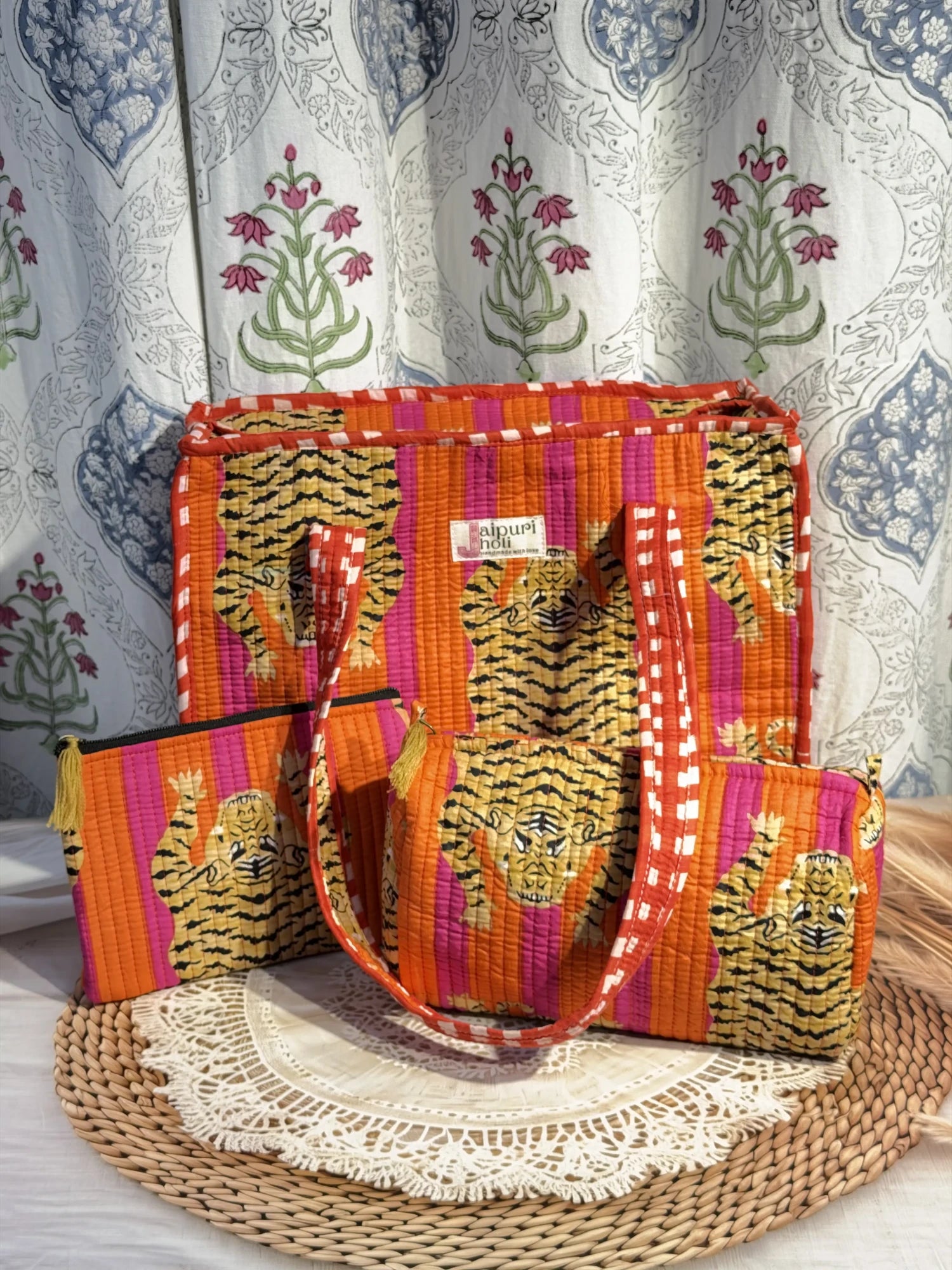 Jaipur block print medium cotton quilted reversible tote bag with matching toiletry pouch and flat pouch, orange and pink tiger print, 15 × 12 × 6 inch tote with button closure, 10 × 6 inch toiletry pouch and 9 × 7 inch flat pouch close-up view