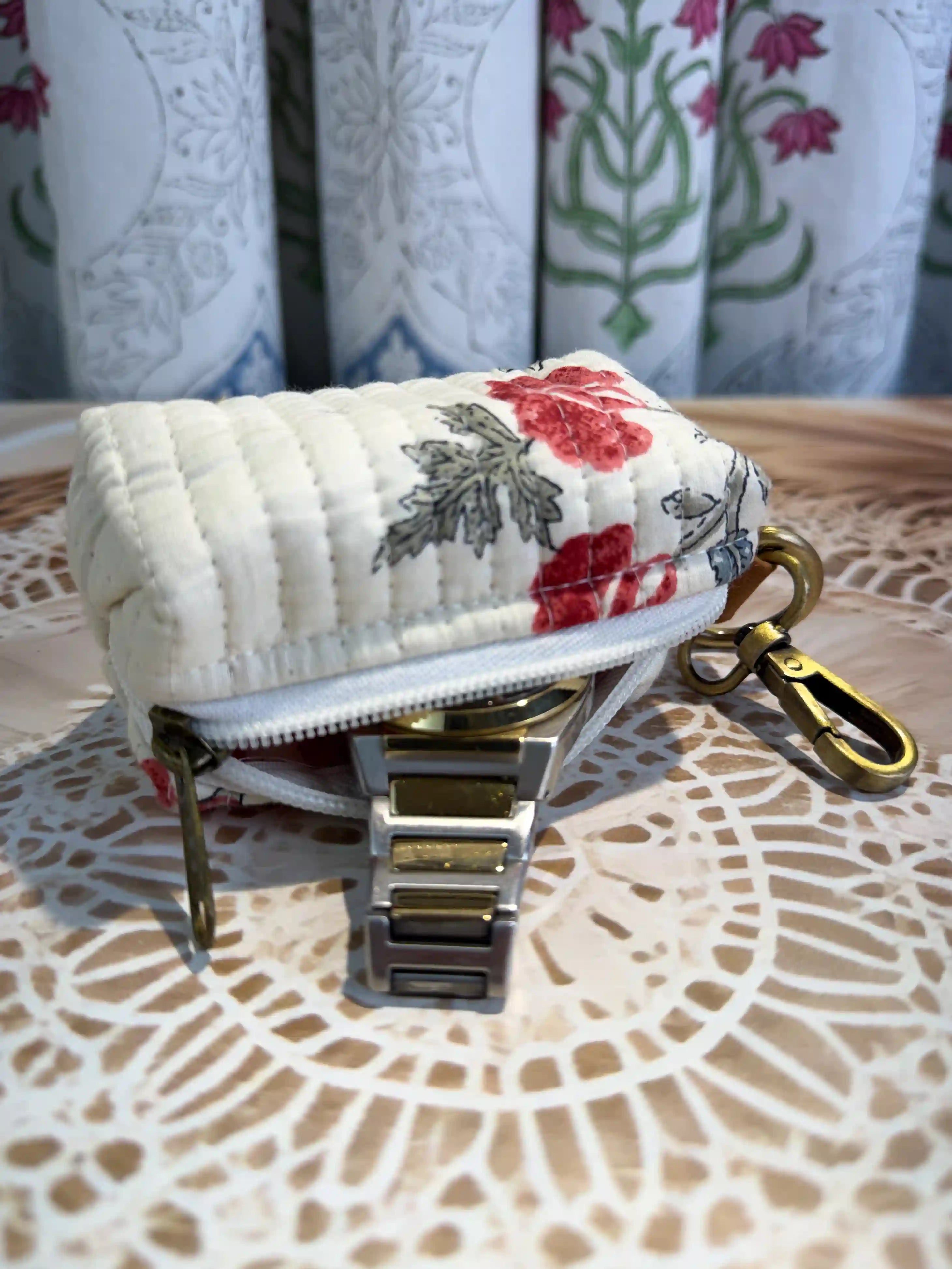 Cream quilted cotton keychain pouch with hand block printed red floral botanical design, zip closure with metal keyring for carrying small essentials and cosmetics.