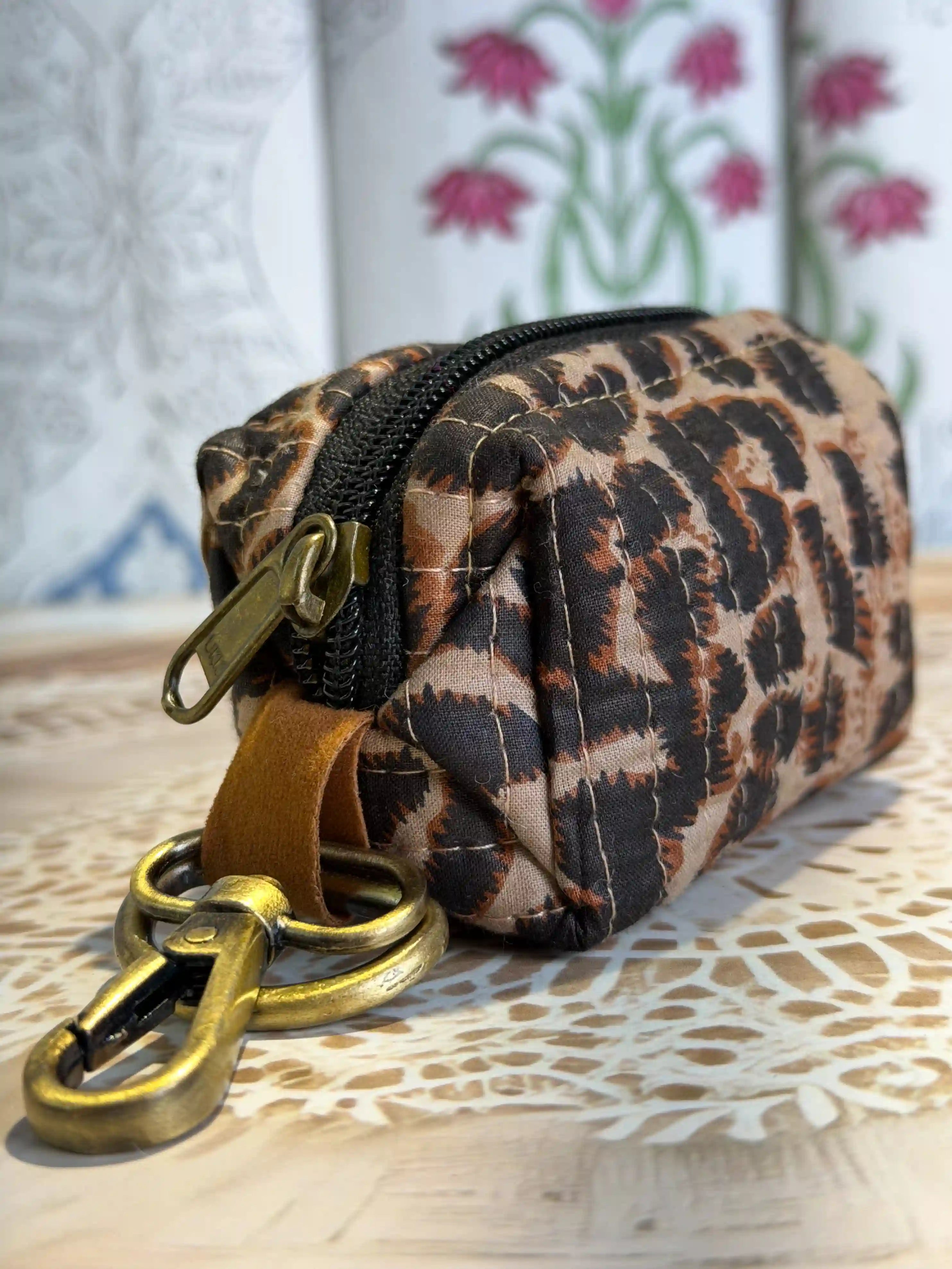 Trending leopard print quilted cotton mini zip pouch in brown and tan with hand block printed design, includes metal keyring attachment for carrying keys and small essentials.