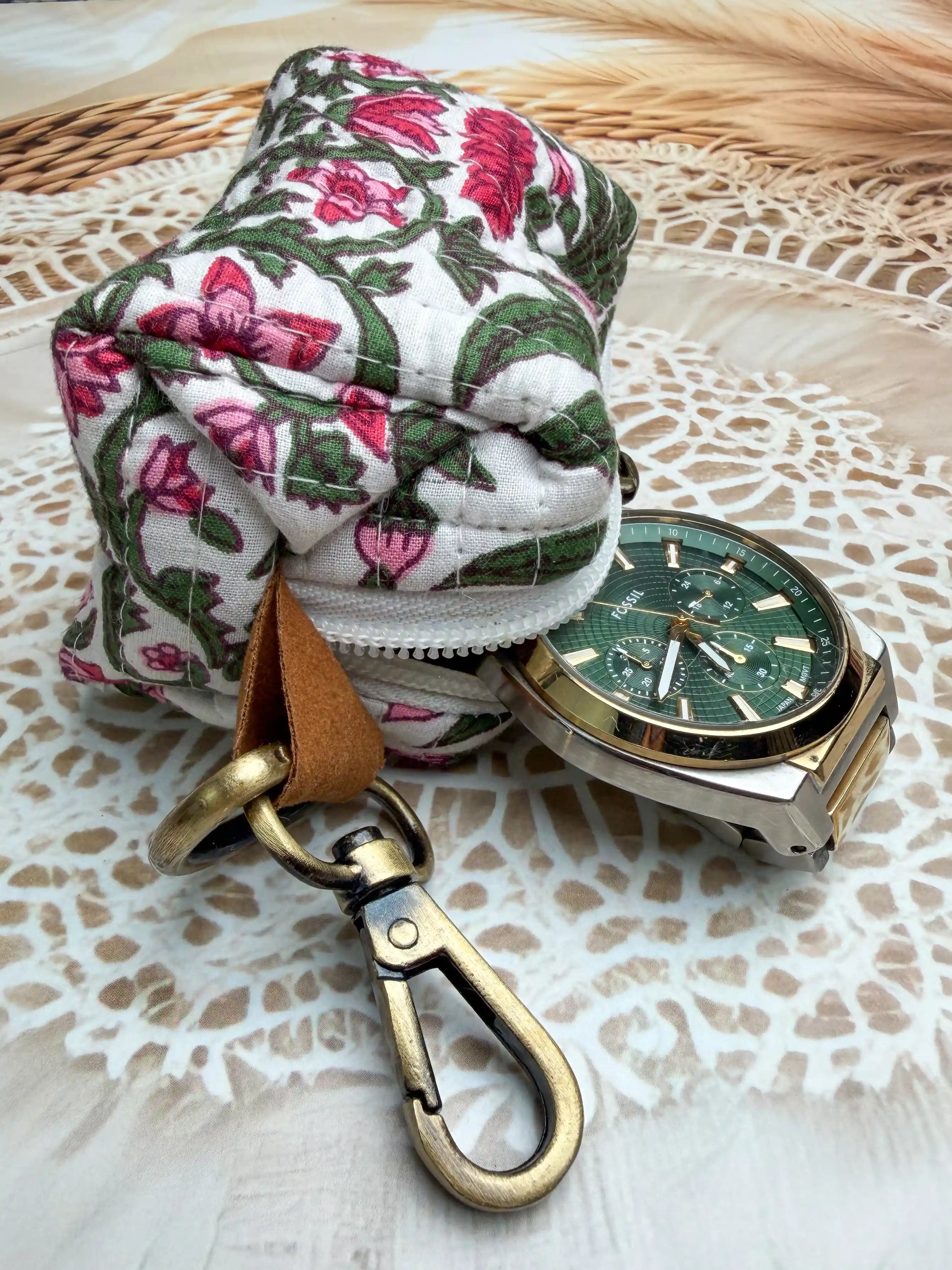 white quilted cotton keychain pouch with hand block printed red and green botanical floral design, durable zipper with metal keyring for carrying coins and essentials.