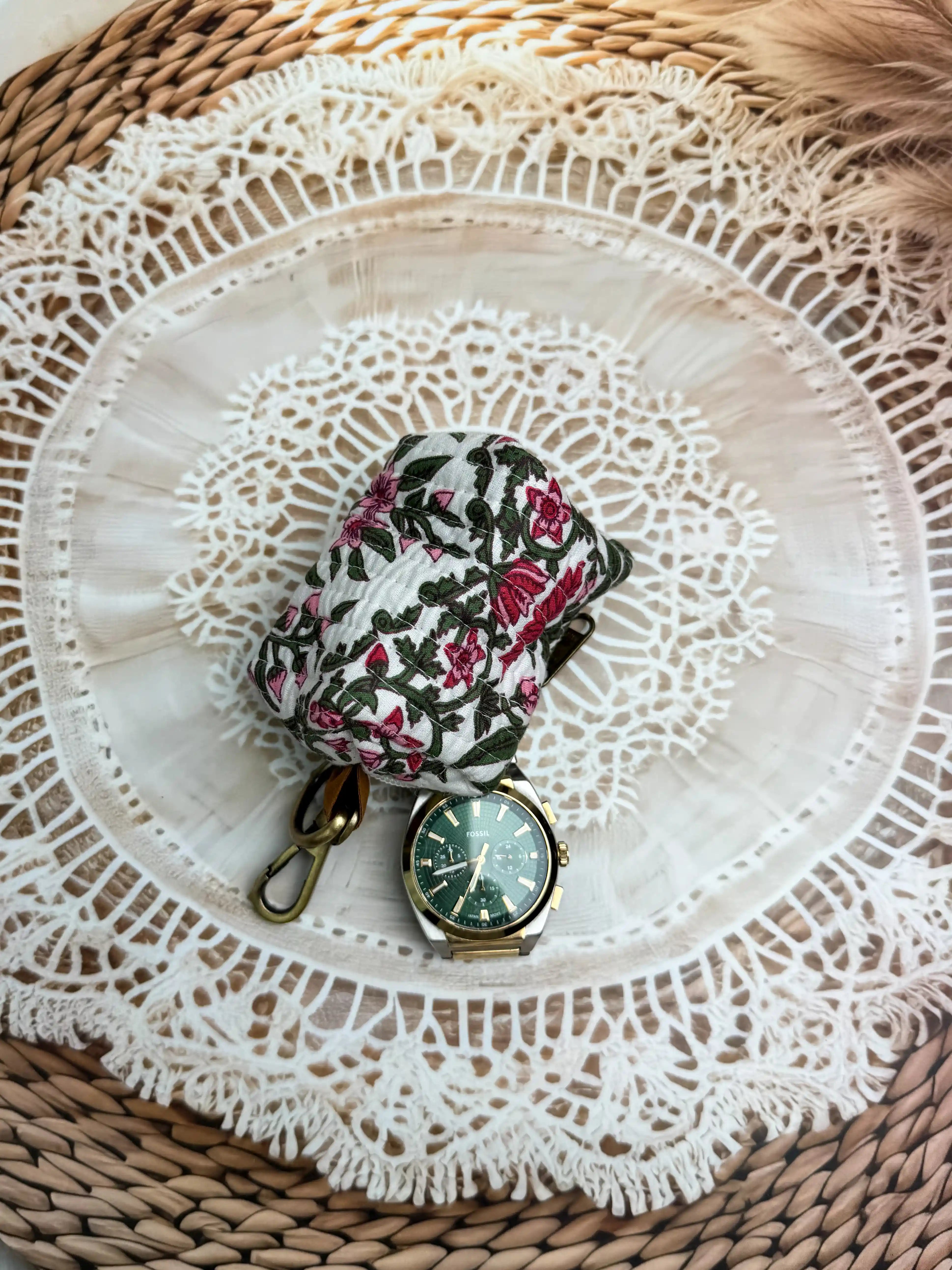 white quilted cotton keychain pouch with hand block printed red and green botanical floral design, durable zipper with metal keyring for carrying coins and essentials.
