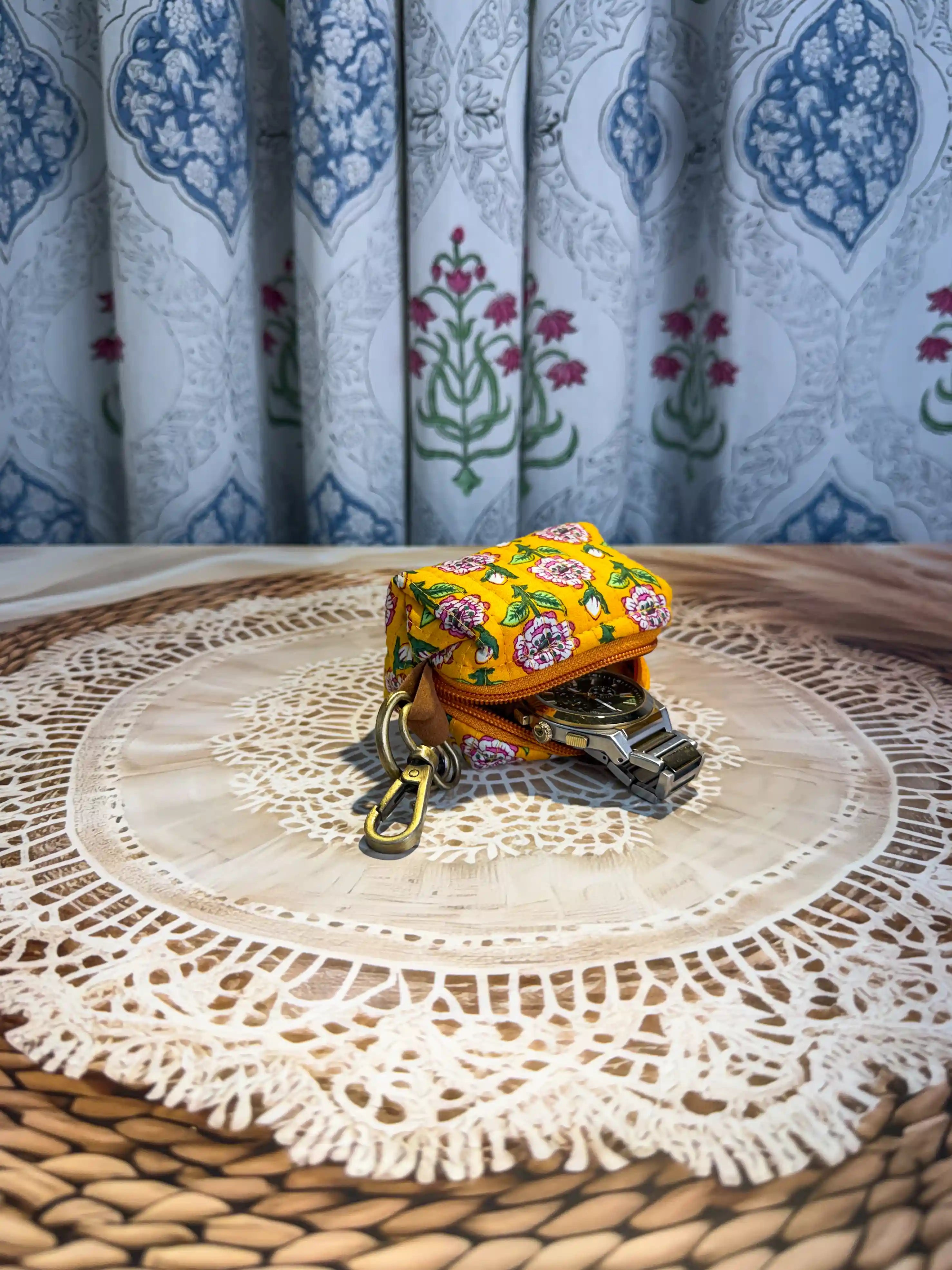 Yellow quilted cotton keychain pouch with hand block printed green geometric and floral elements, includes zip closure and keyring for organizing keys and small items.