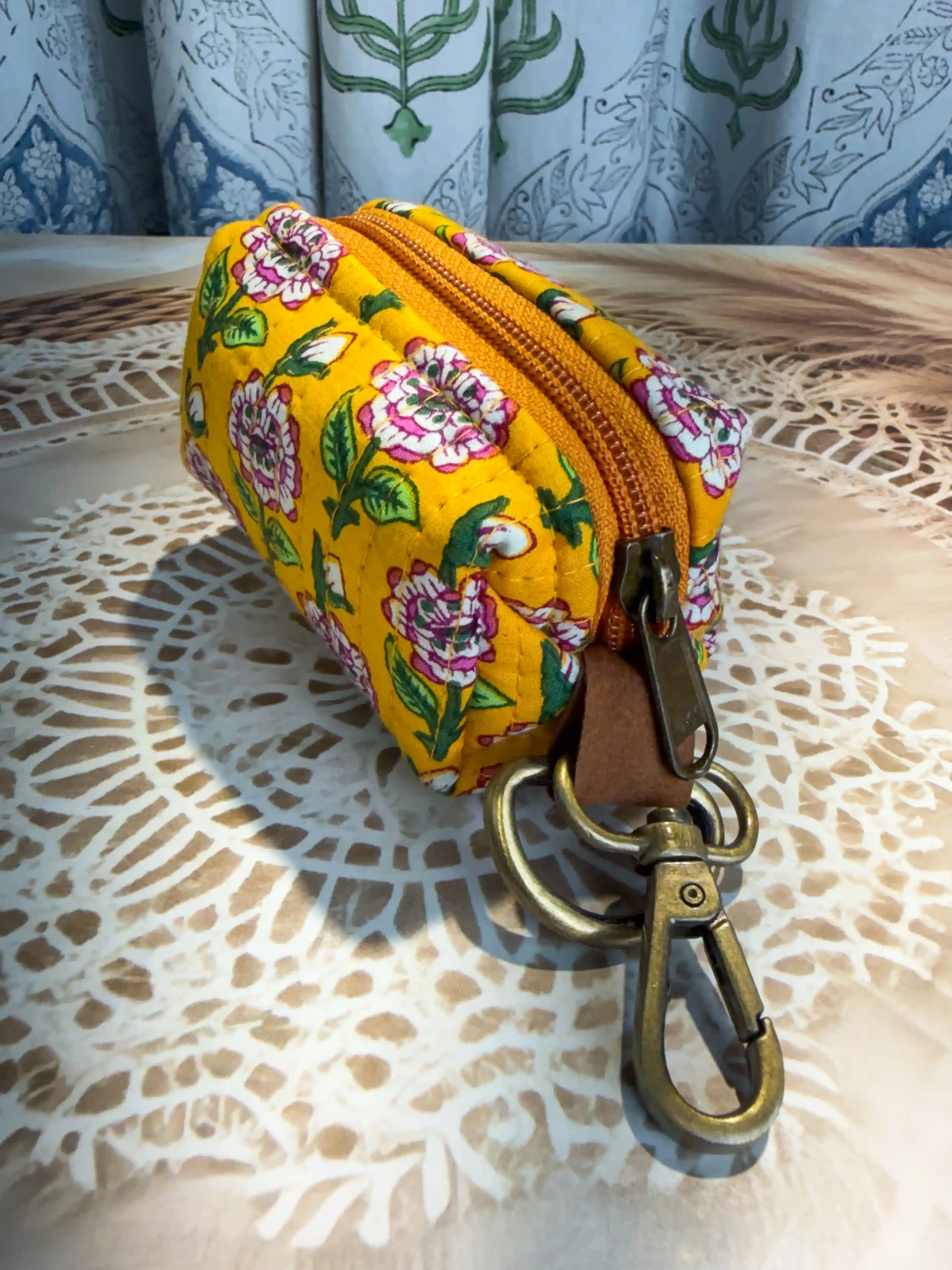 Yellow quilted cotton keychain pouch with hand block printed green geometric and floral elements, includes zip closure and keyring for organizing keys and small items.
