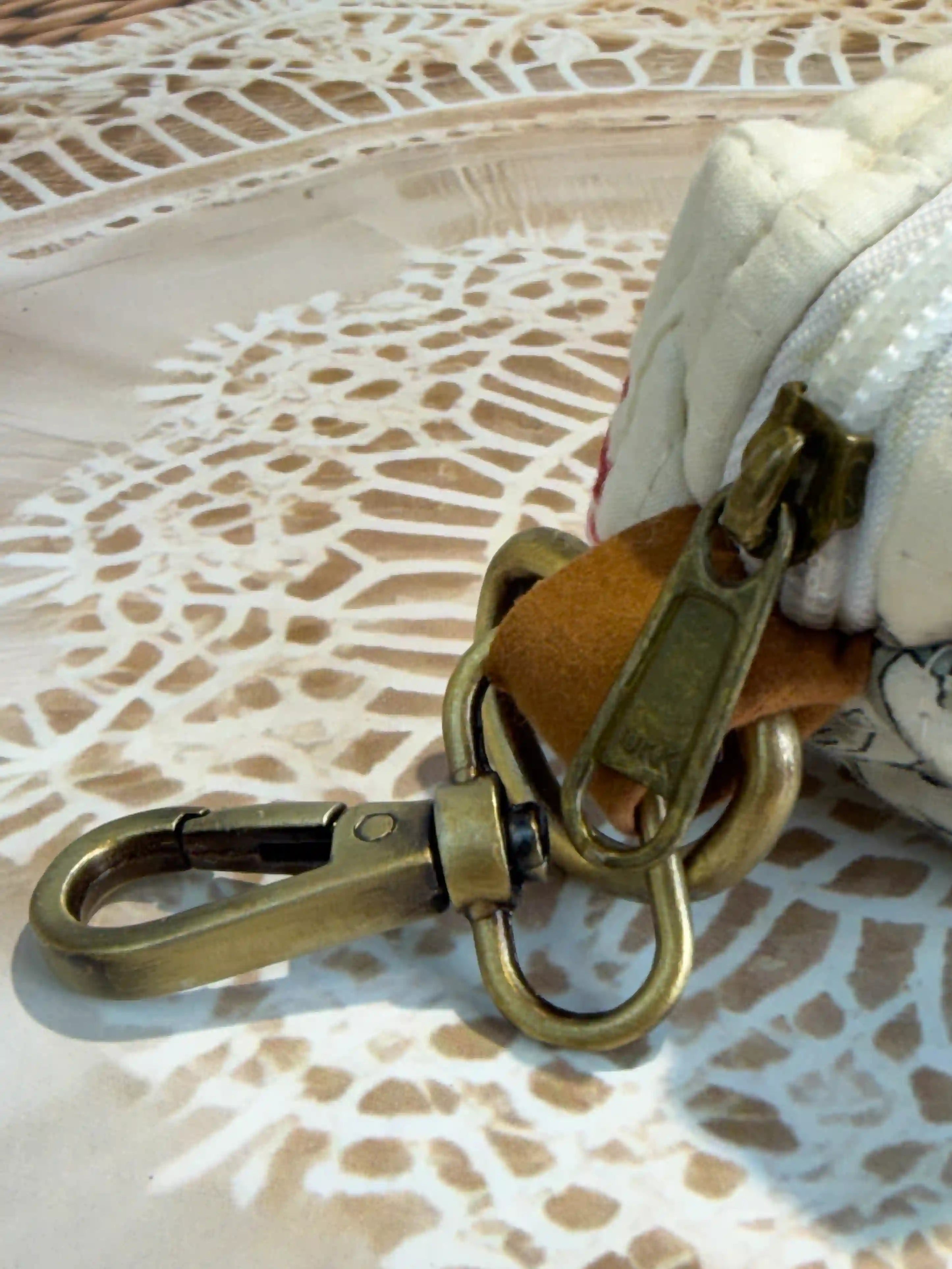 Cream quilted cotton keychain pouch with hand block printed red floral botanical design, zip closure with metal keyring for carrying small essentials and cosmetics.